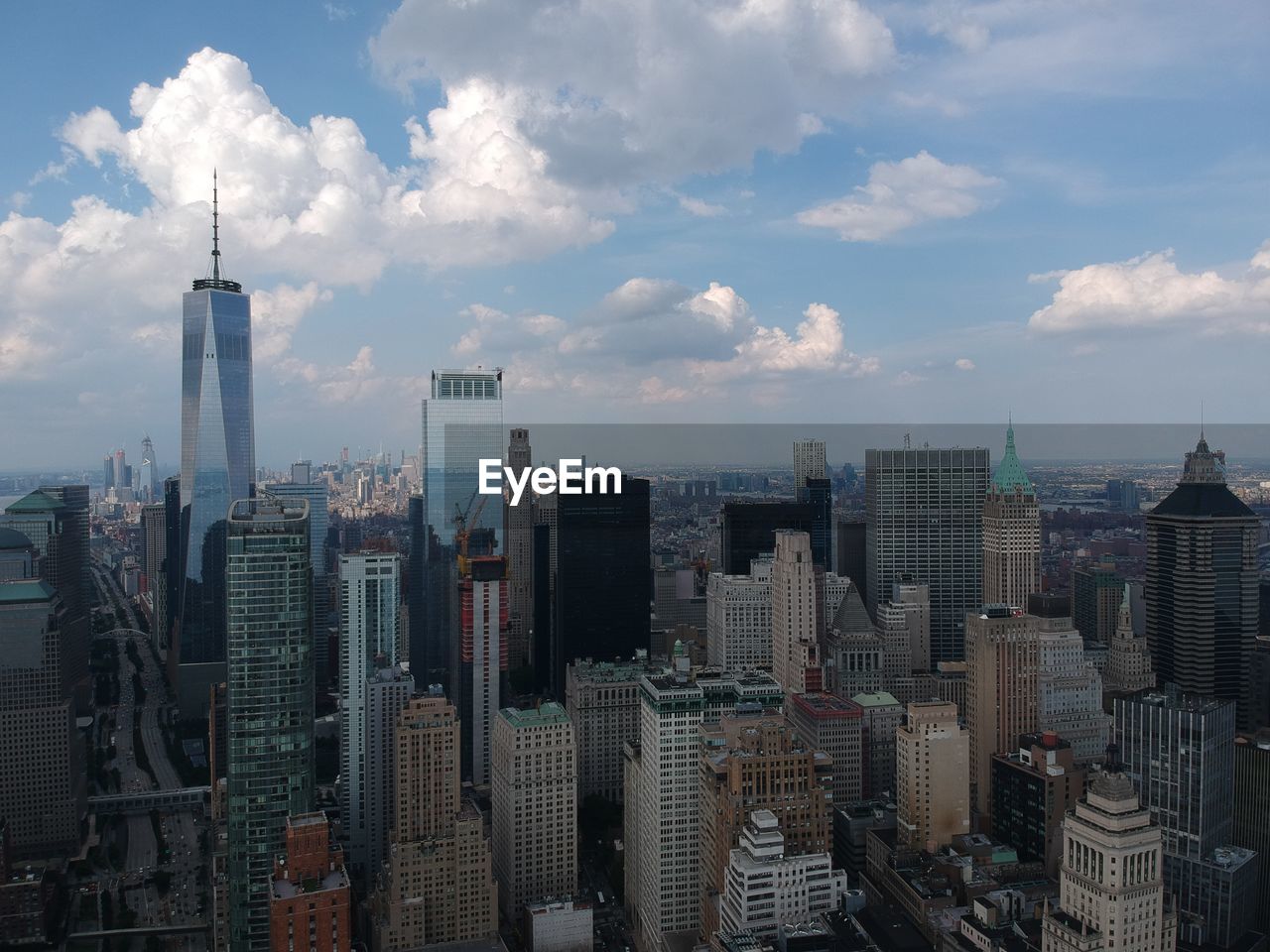 Aerial view of buildings in city against cloudy sky