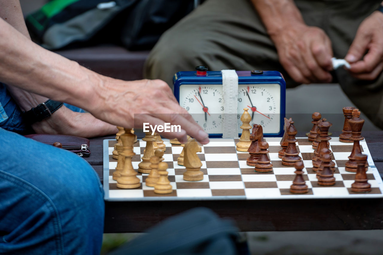 Midsection of men playing chess on board