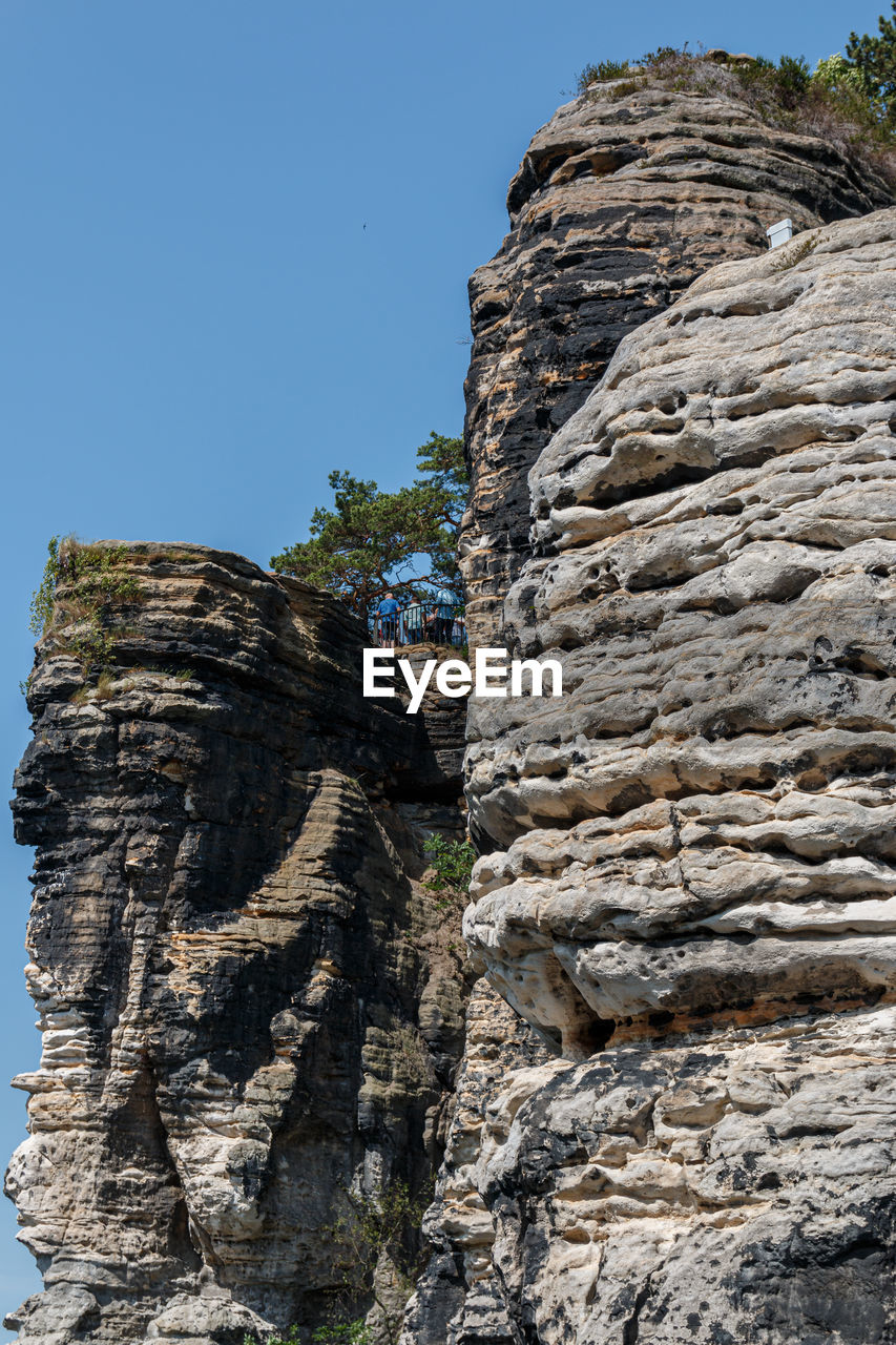 LOW ANGLE VIEW OF ROCK FORMATIONS AGAINST CLEAR SKY