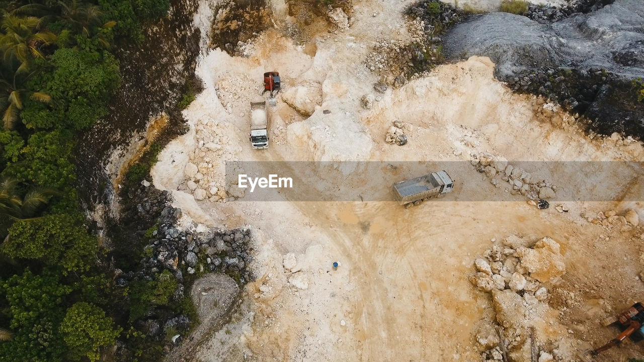 Aerial view wheel loader excavator machine loading dumper truck at quarry. 