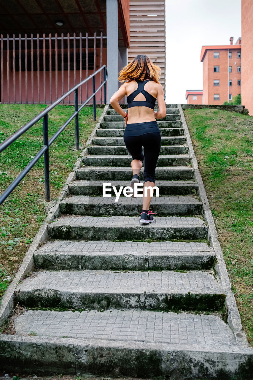 Rear view of woman running on staircase