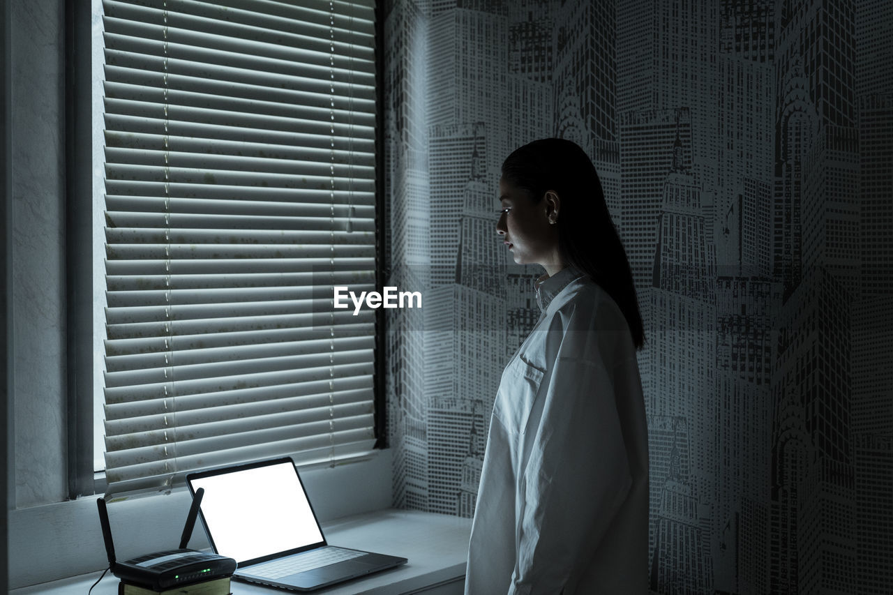 WOMAN LOOKING THROUGH WINDOW