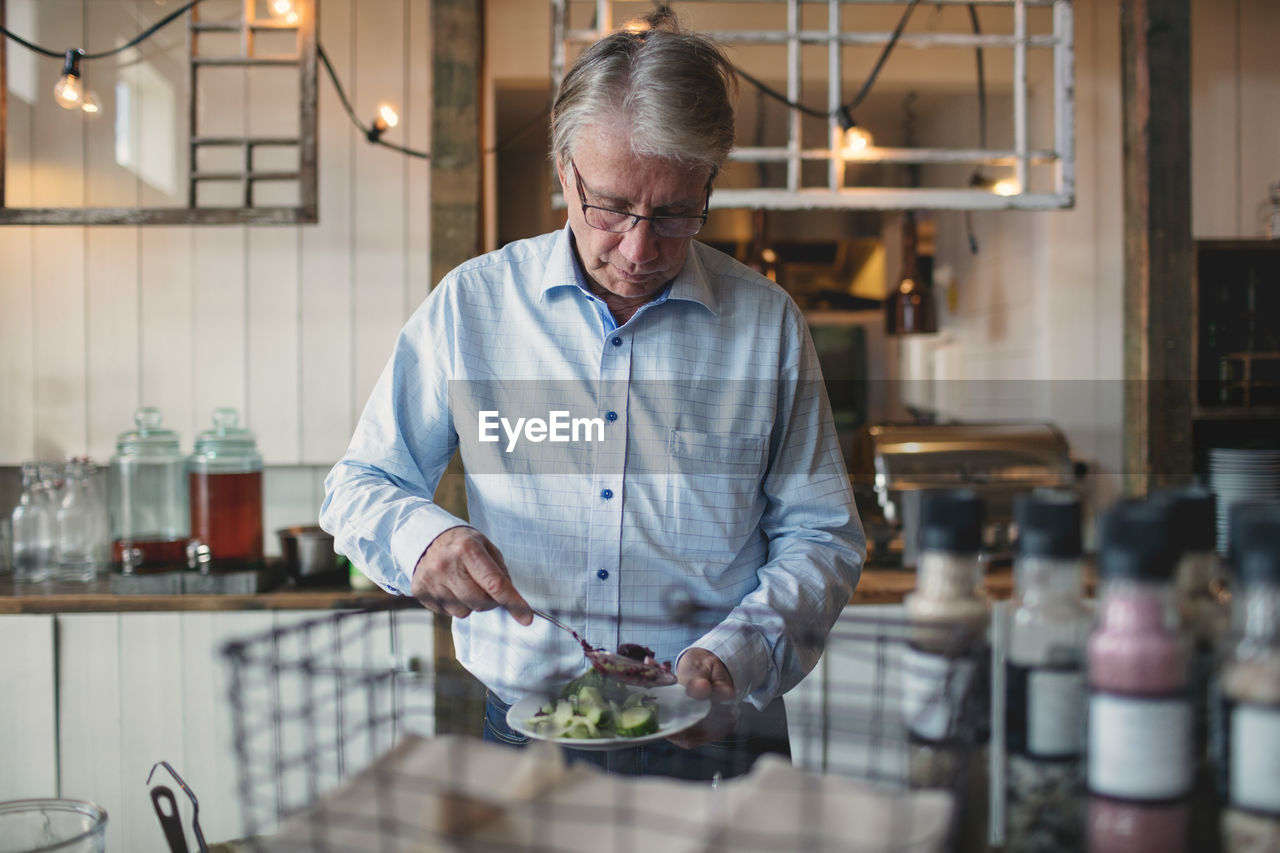 Senior man taking food in plate at buffet counter