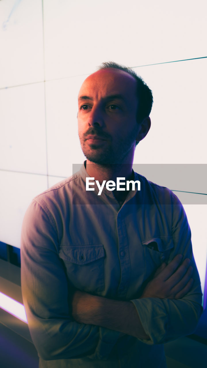 Portrait of young man standing at the side of a led wall