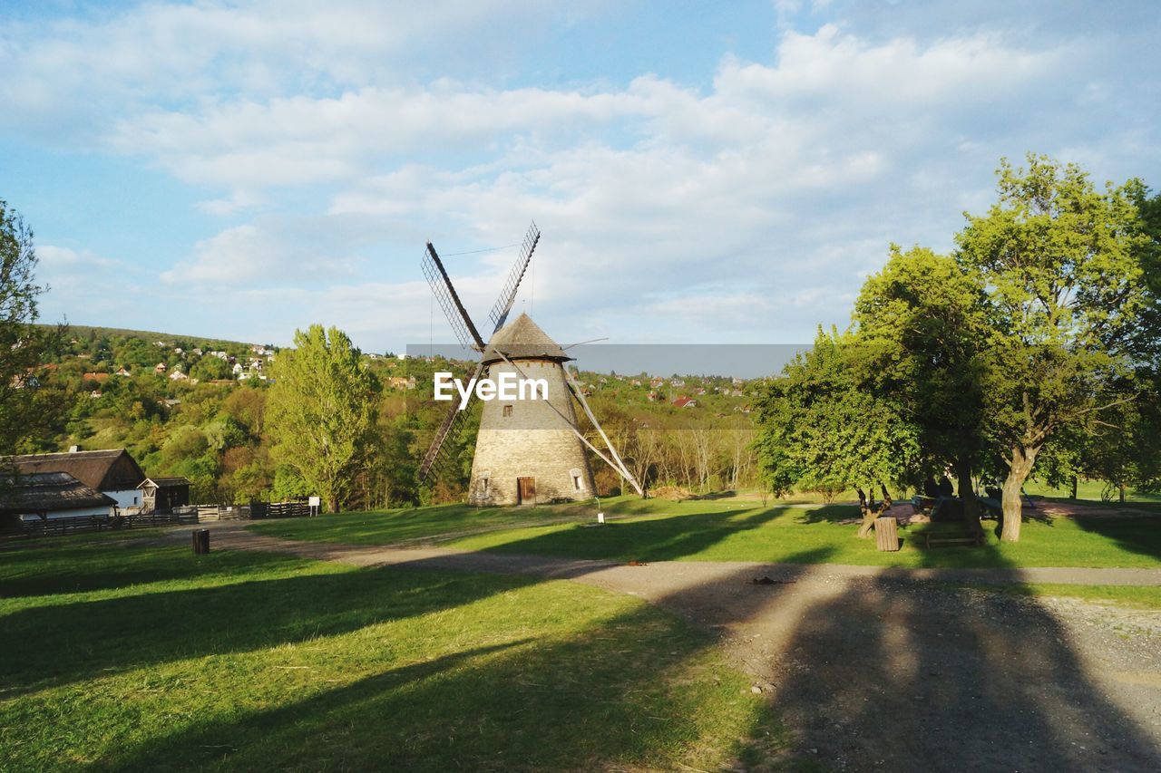 Traditional windmill on field against sky