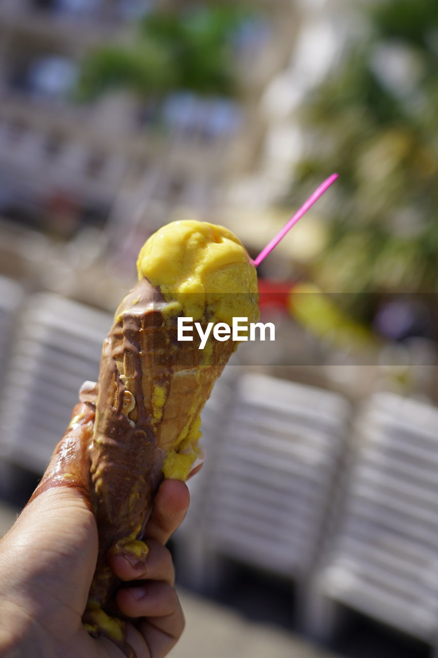 CLOSE-UP OF PERSON HOLDING ICE CREAM CONE