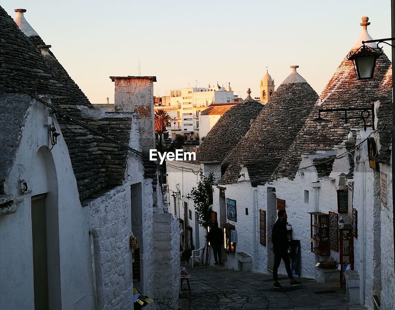 REAR VIEW OF WOMAN WALKING ON BUILDINGS