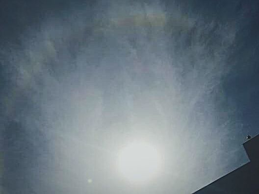 LOW ANGLE VIEW OF SUN SHINING THROUGH CLOUDS