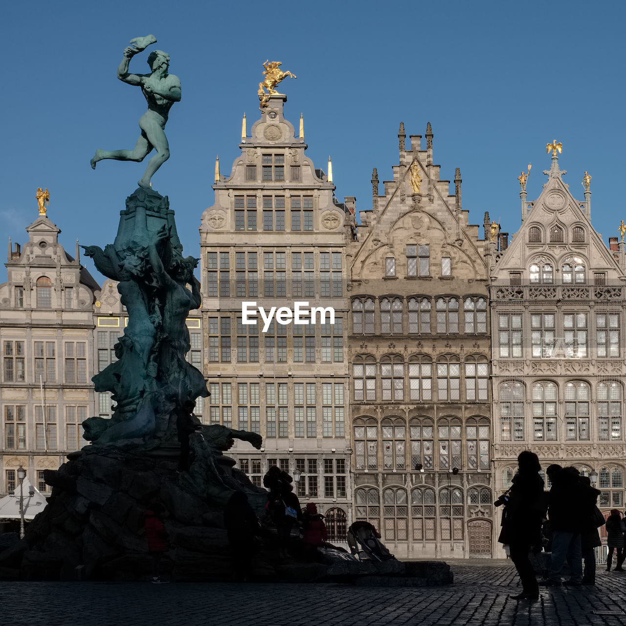 Statue of brabo on the grote markt square of antwerp  against blue sky