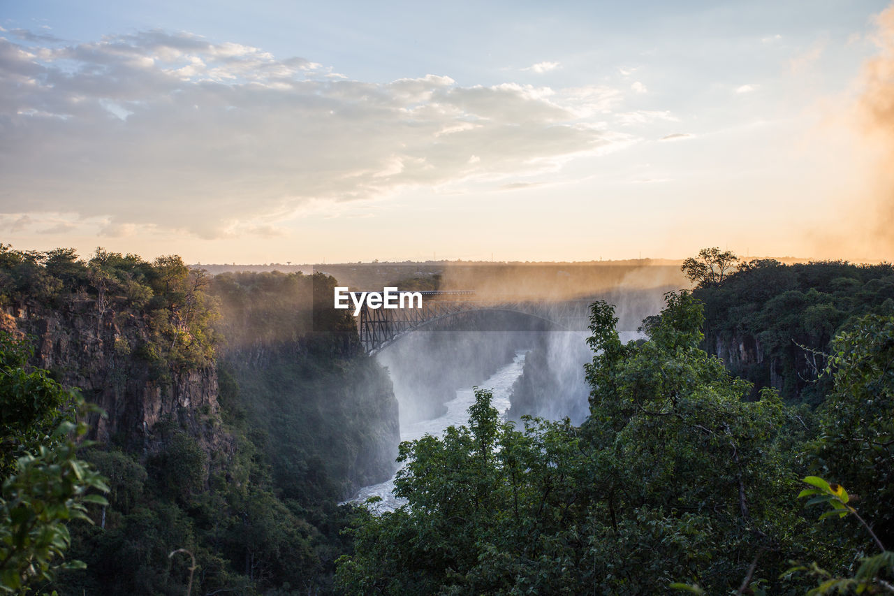 Sunset at victoria falls zimbabwe with the sun cutting through the mist. 