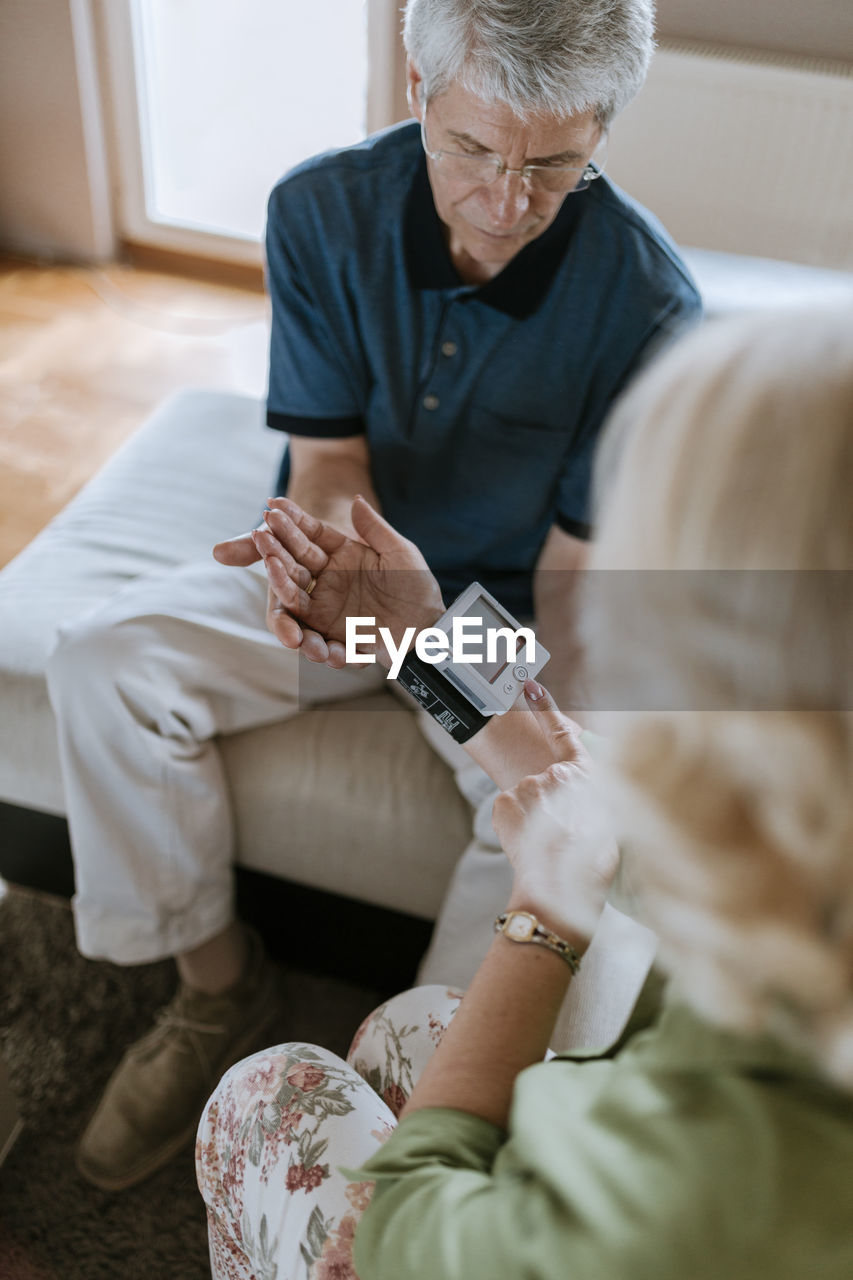 Senior couple taking blood pressure at home