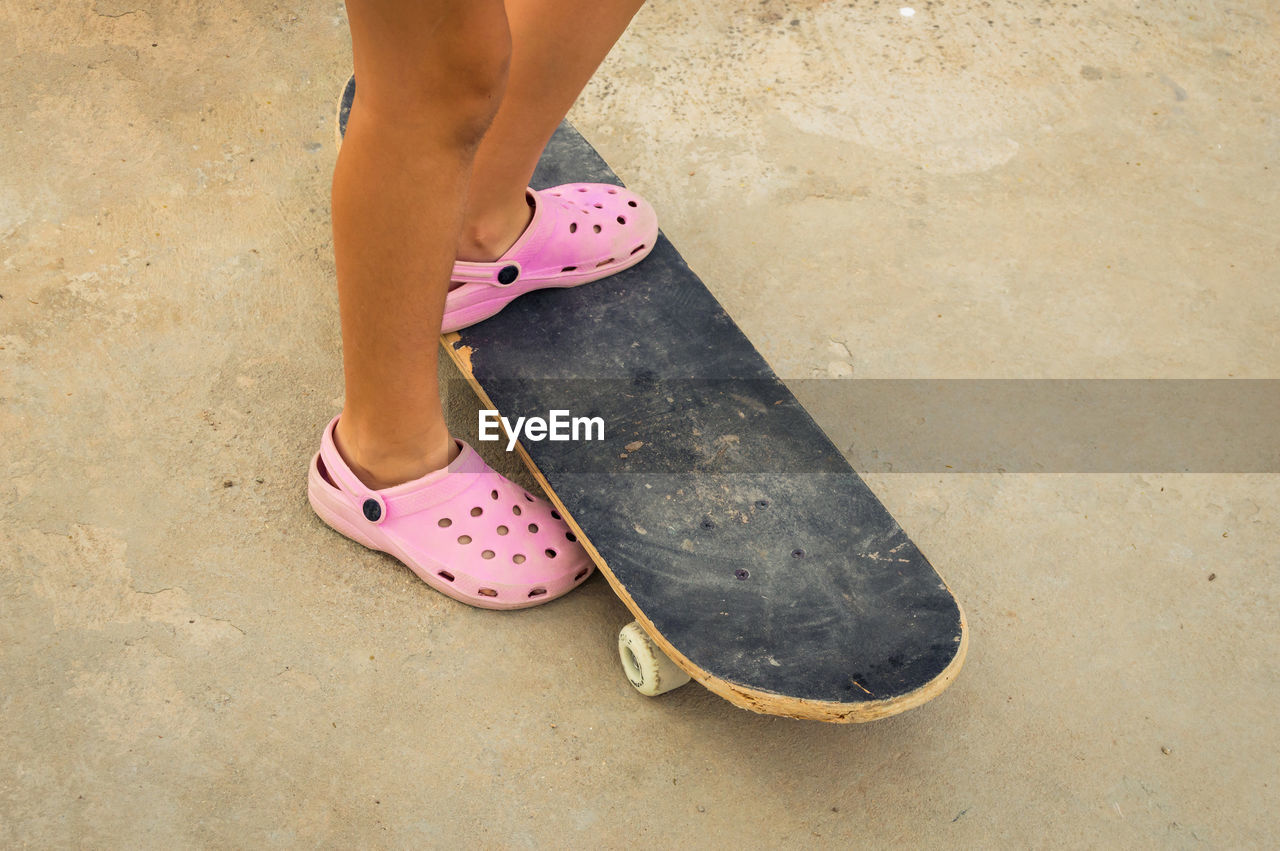 Low section of woman standing on skateboard