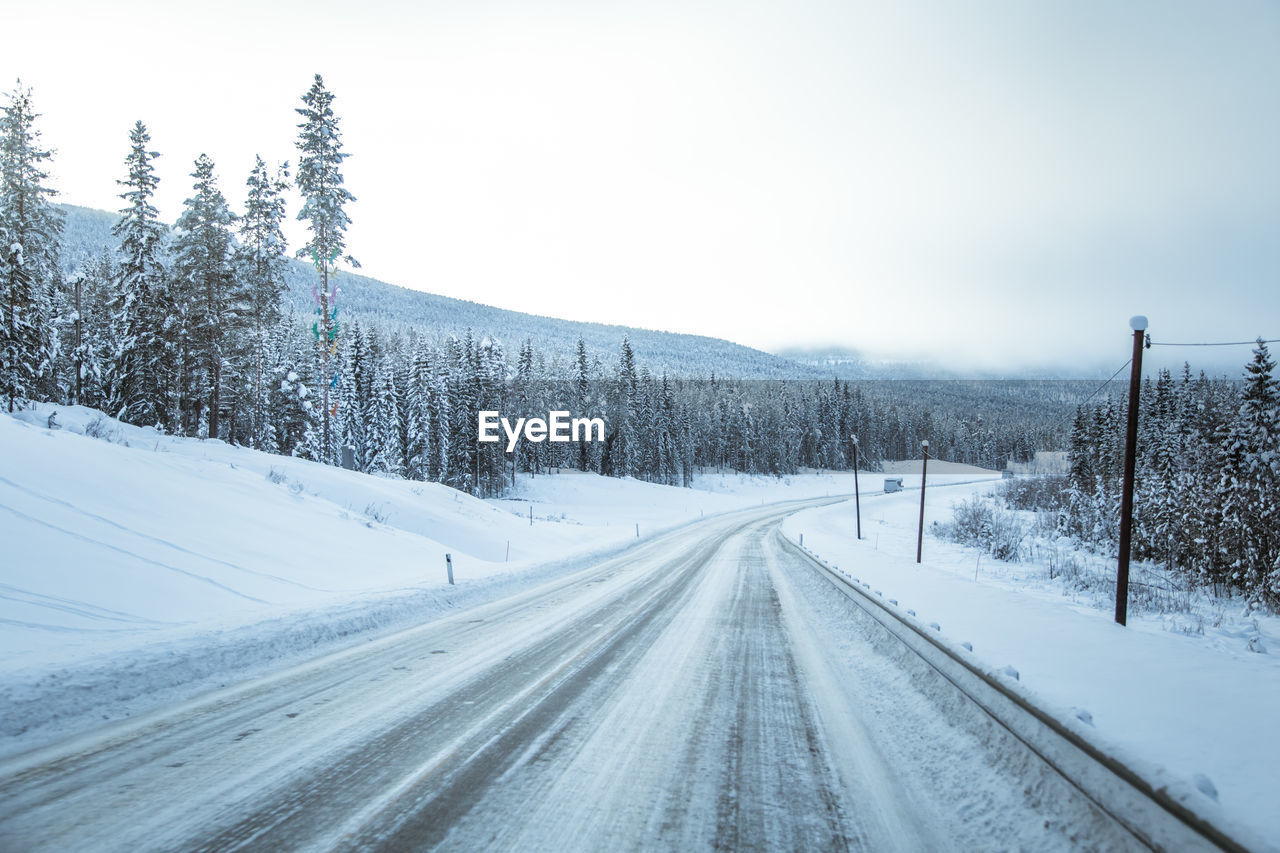 Snow covered road against sky