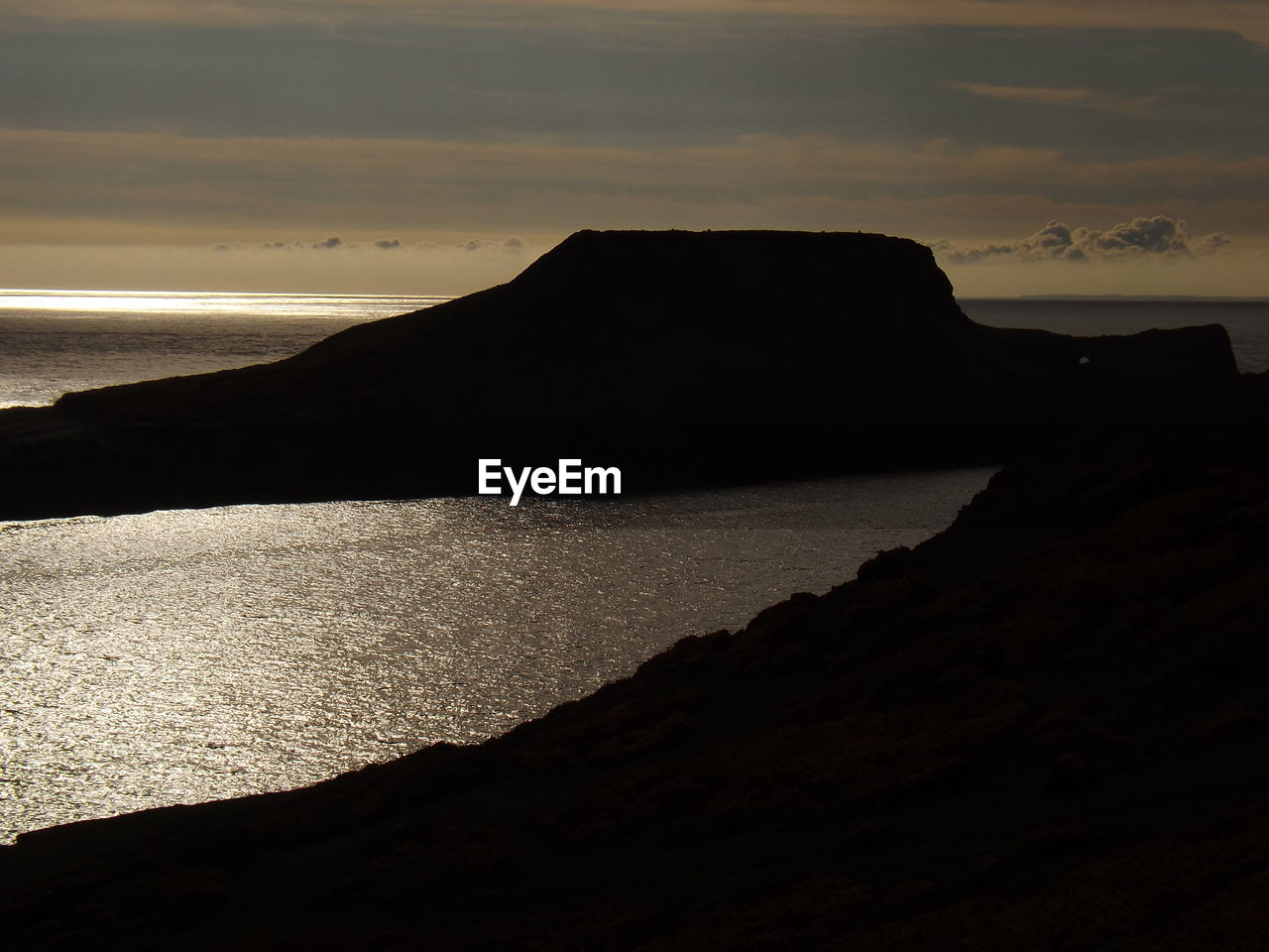 SCENIC VIEW OF SILHOUETTE MOUNTAIN BY SEA AGAINST SKY