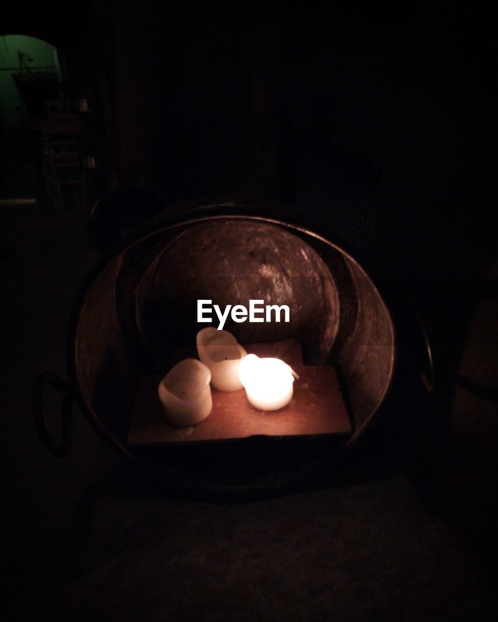 HIGH ANGLE VIEW OF ILLUMINATED TEA LIGHT CANDLE ON TABLE