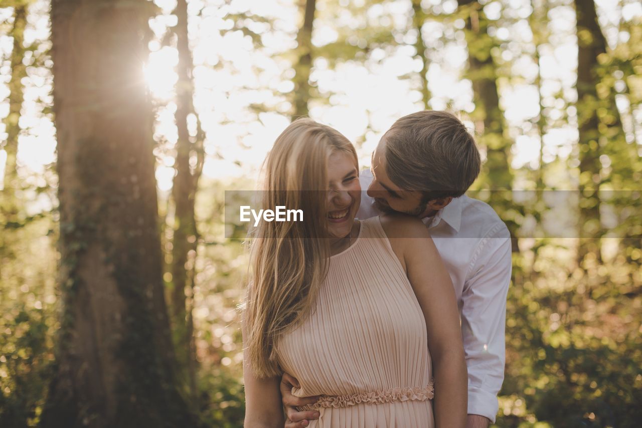 Happy couple standing in forest