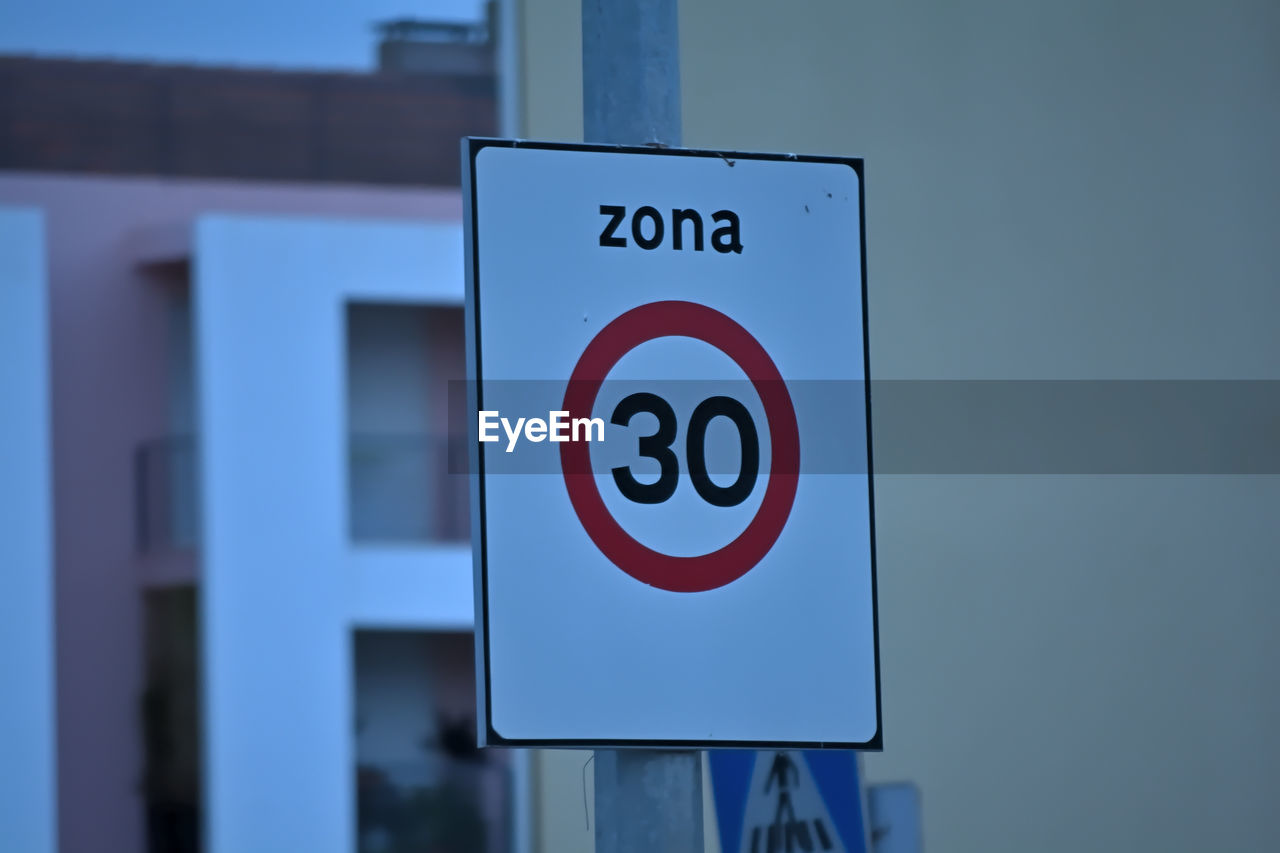 sign, communication, signage, blue, road sign, warning sign, no people, text, traffic sign, guidance, western script, information sign, street sign, road, advertising, close-up, no smoking sign, architecture, forbidden, day, symbol, focus on foreground, outdoors