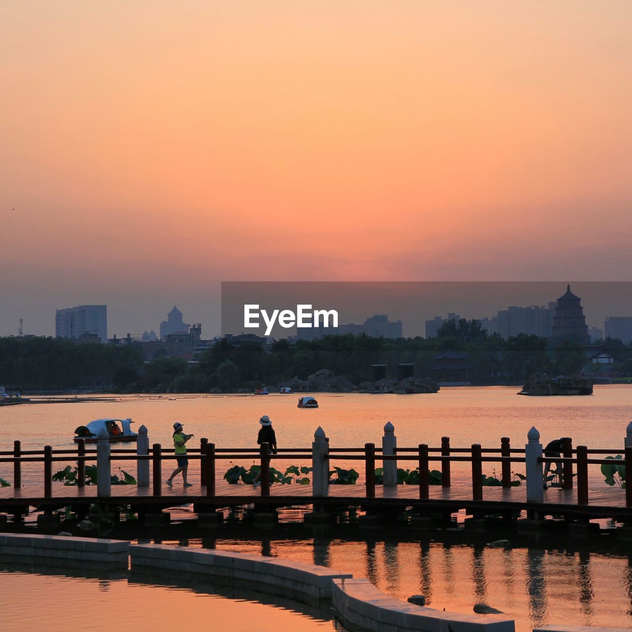 People on pier during sunset