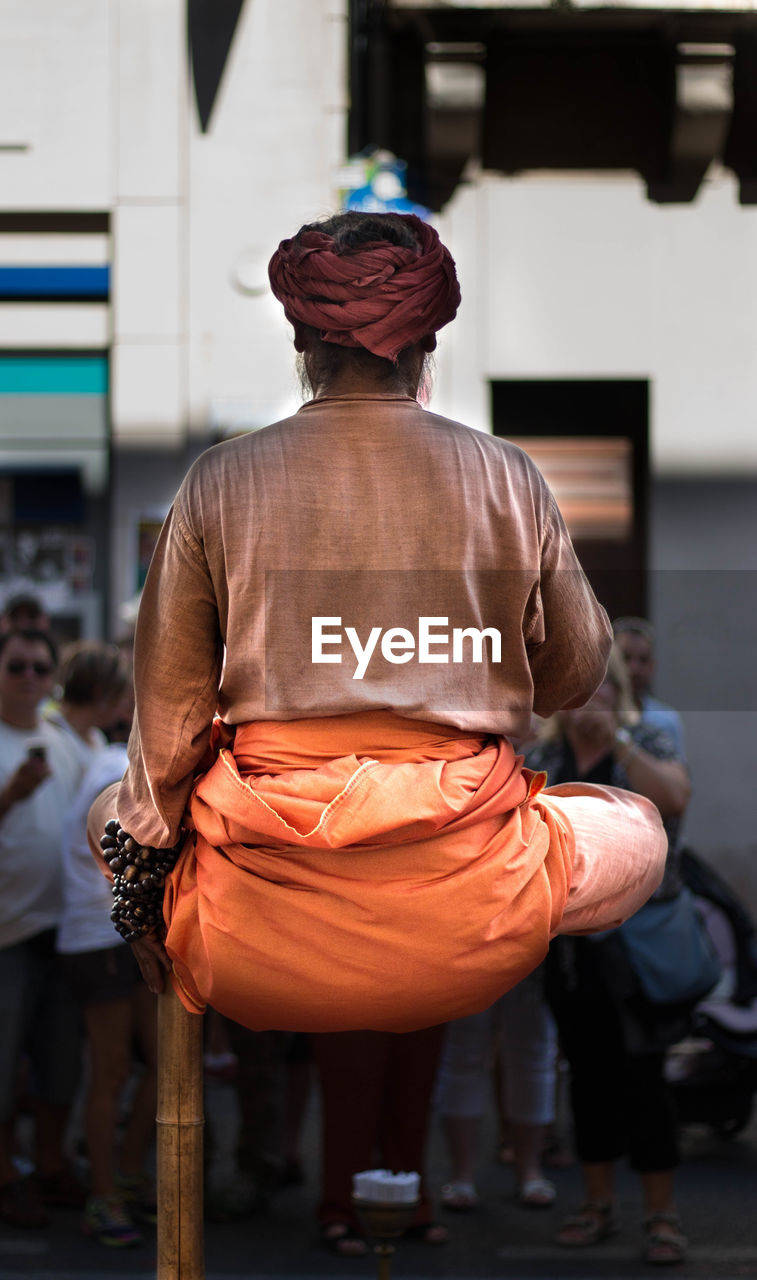 Rear view of magician performing on street