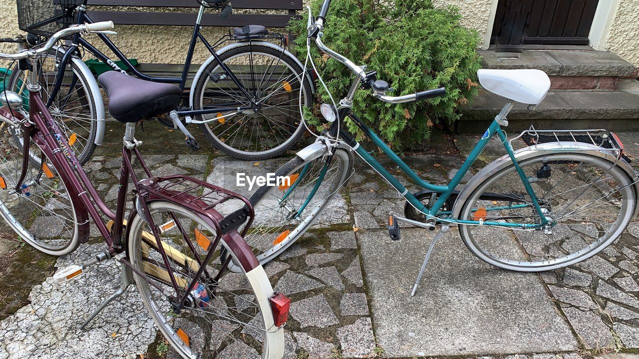 BICYCLE PARKED BY FOOTPATH