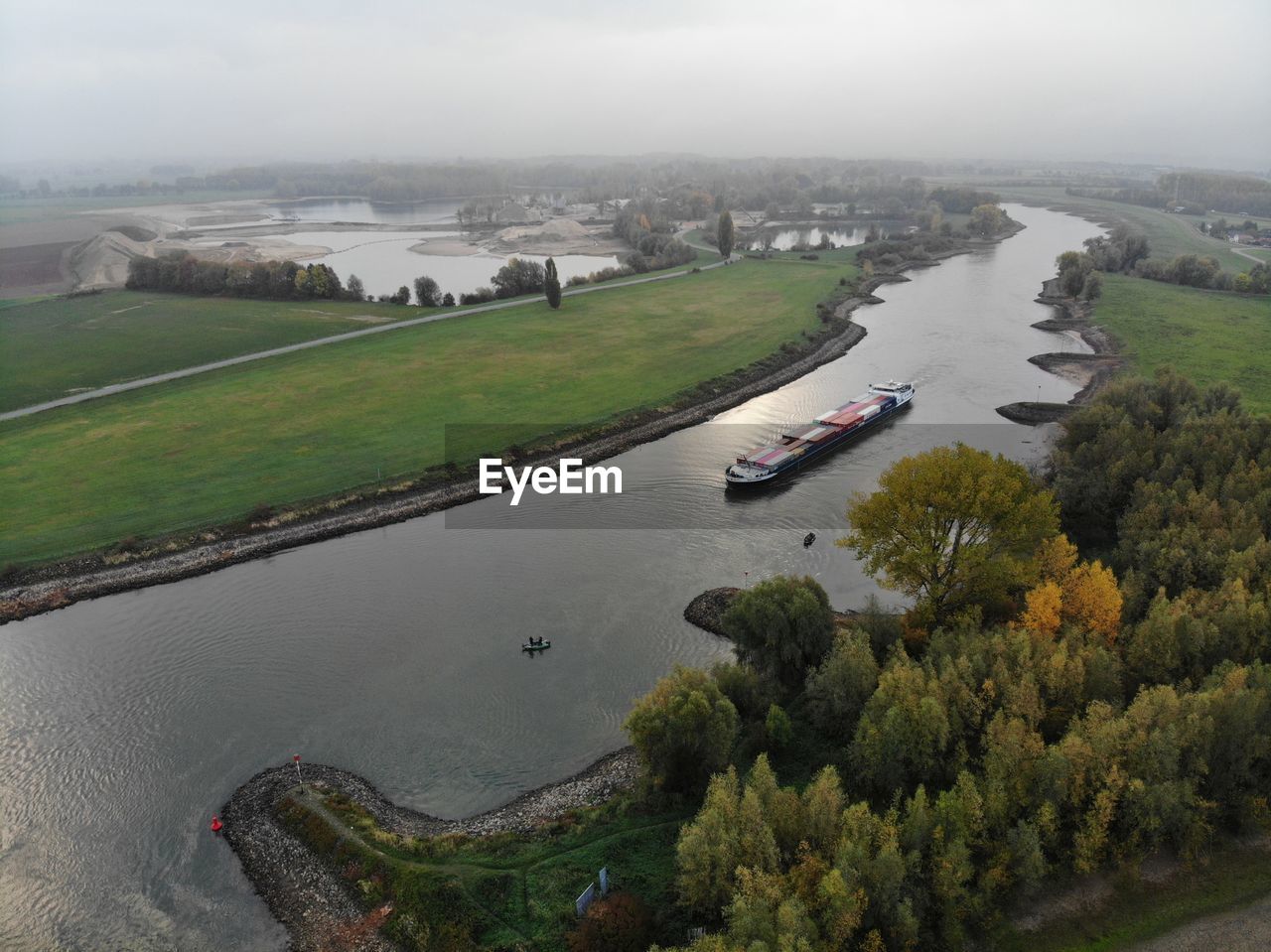 HIGH ANGLE VIEW OF RIVER AMIDST TREES AND PLANTS