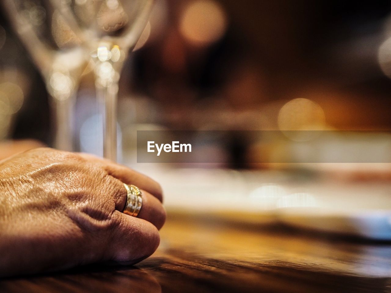 Cropped hand of senior person wearing ring on table