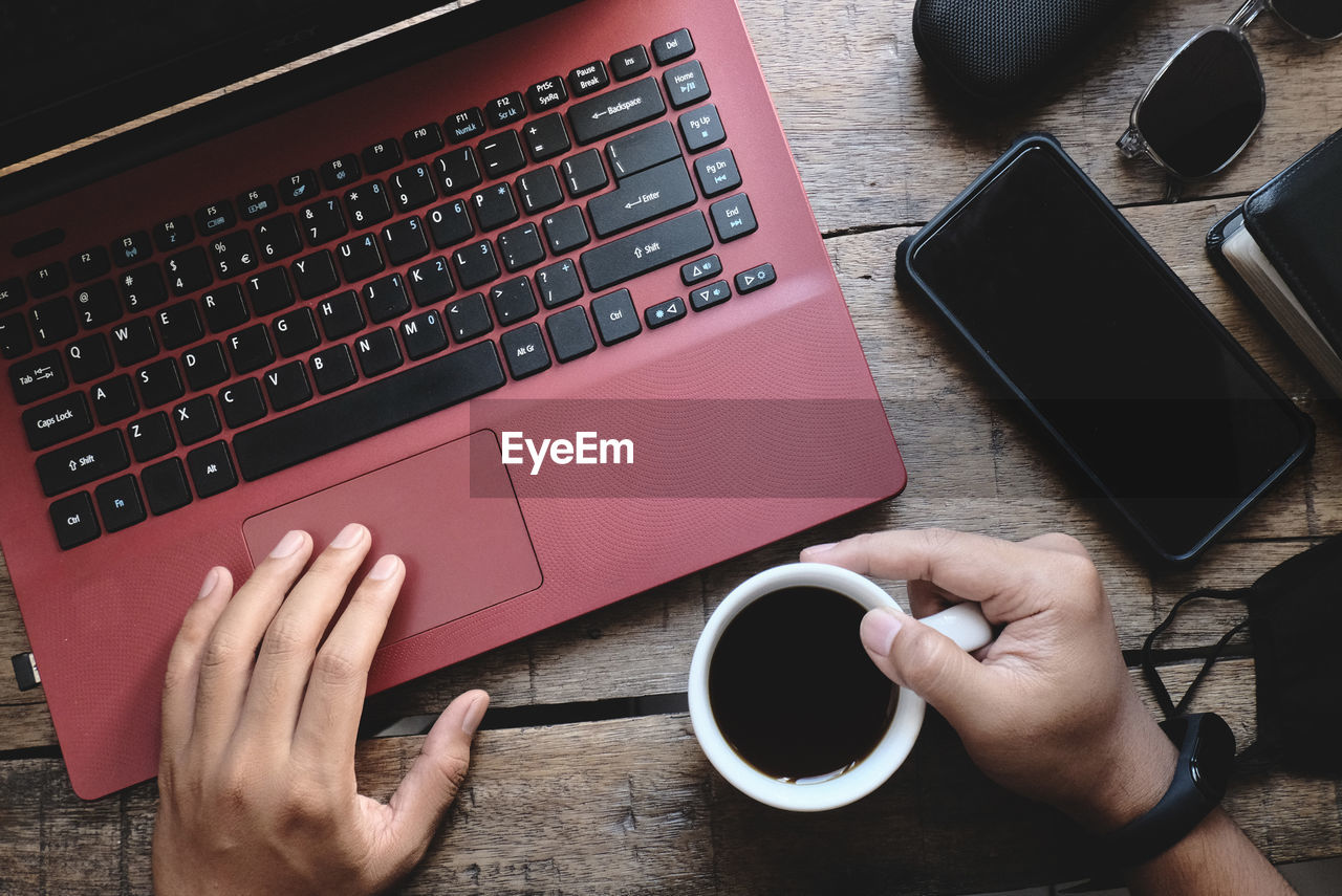 Midsection of man using laptop on table