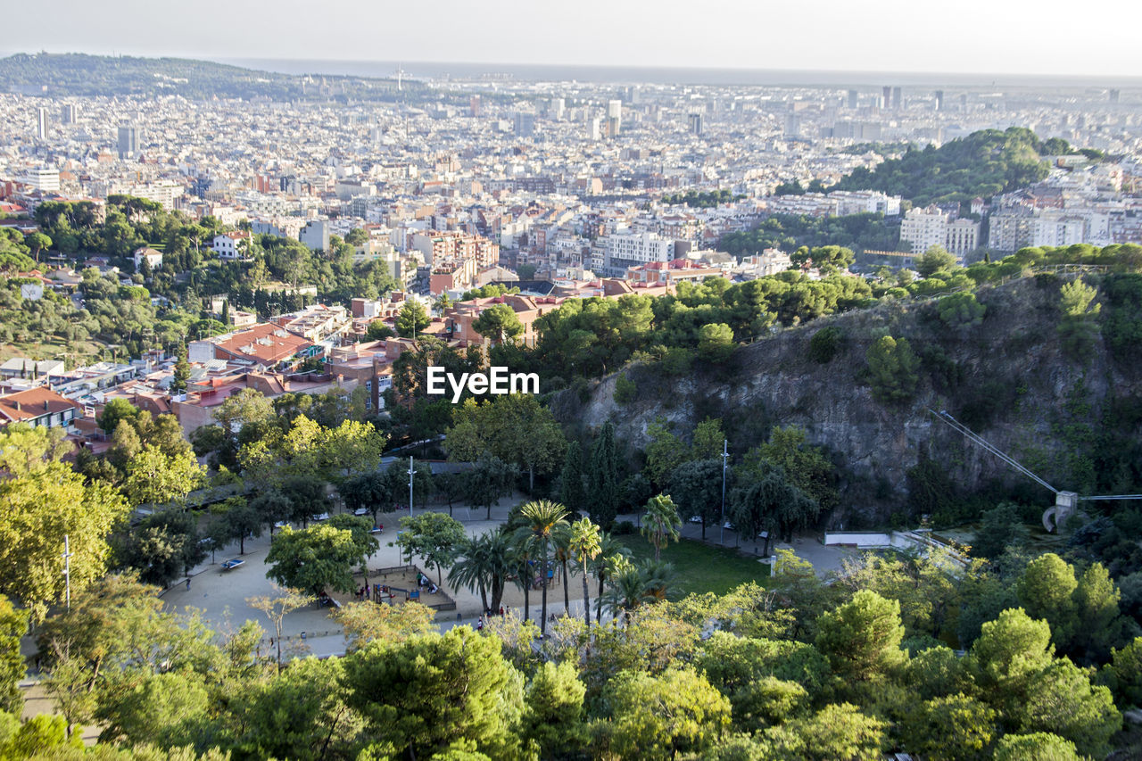 Aerial view of cityscape and trees against sky