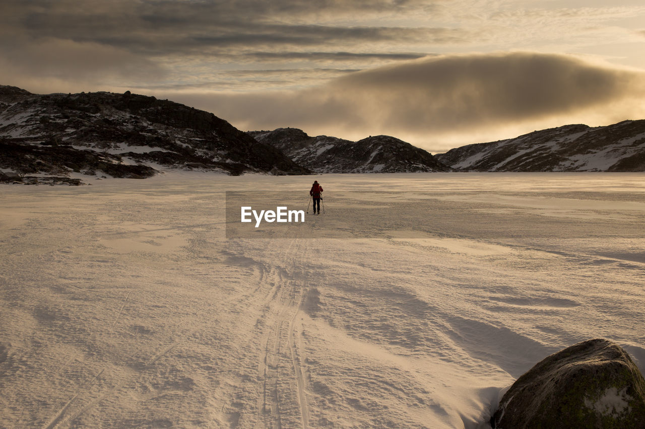 Rear view of person skiing on snow covered field