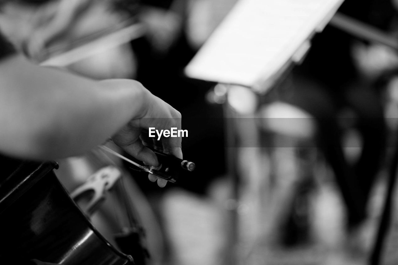 Close-up of person playing cello in orchestra