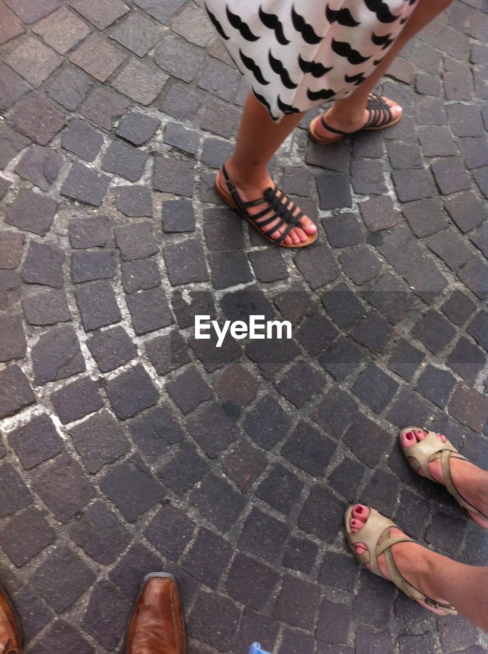 LOW SECTION OF PEOPLE STANDING ON PAVING STONE