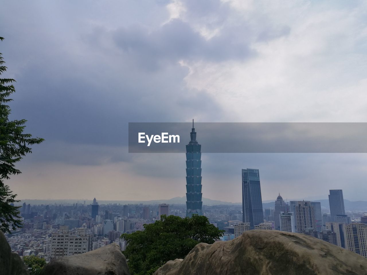 View of cityscape against cloudy sky