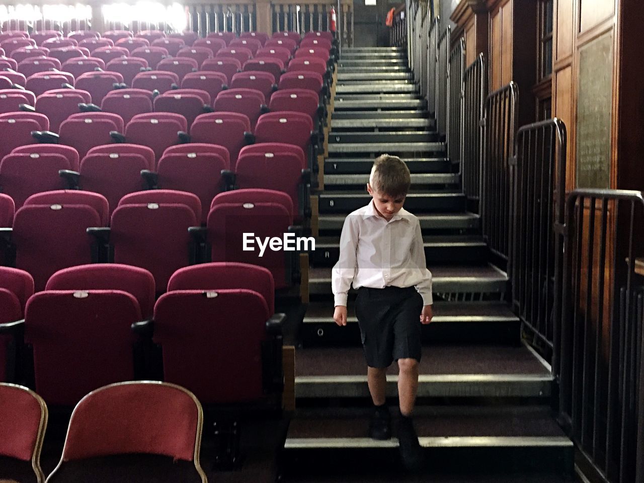 Boy moving down on steps in stage theater