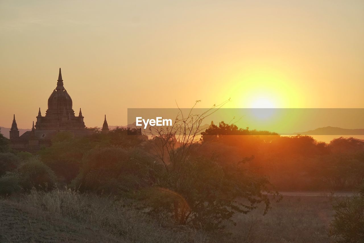 PANORAMIC VIEW OF TEMPLE AGAINST BUILDING DURING SUNSET