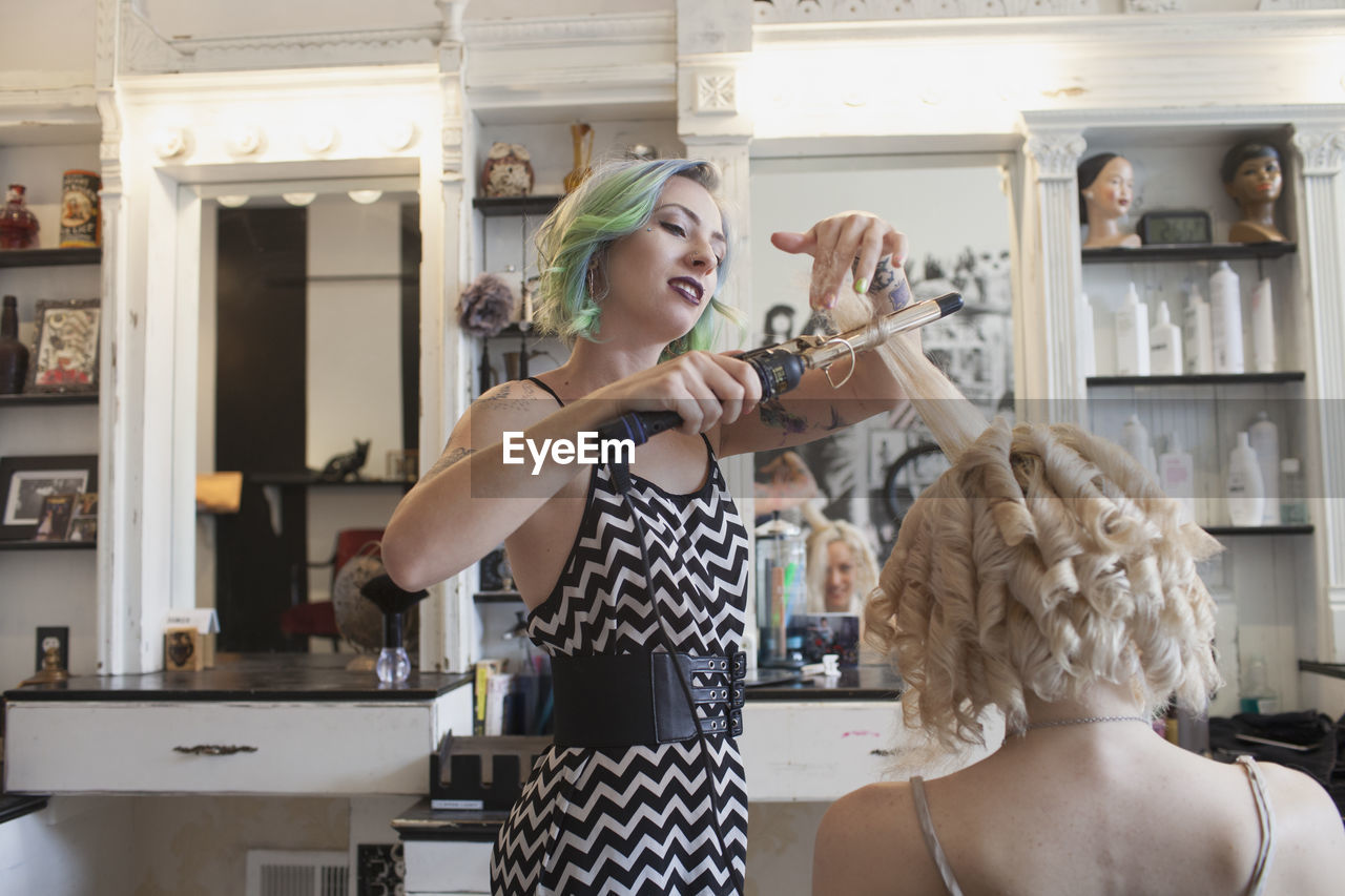 A hair dresser styling a customer's hair.