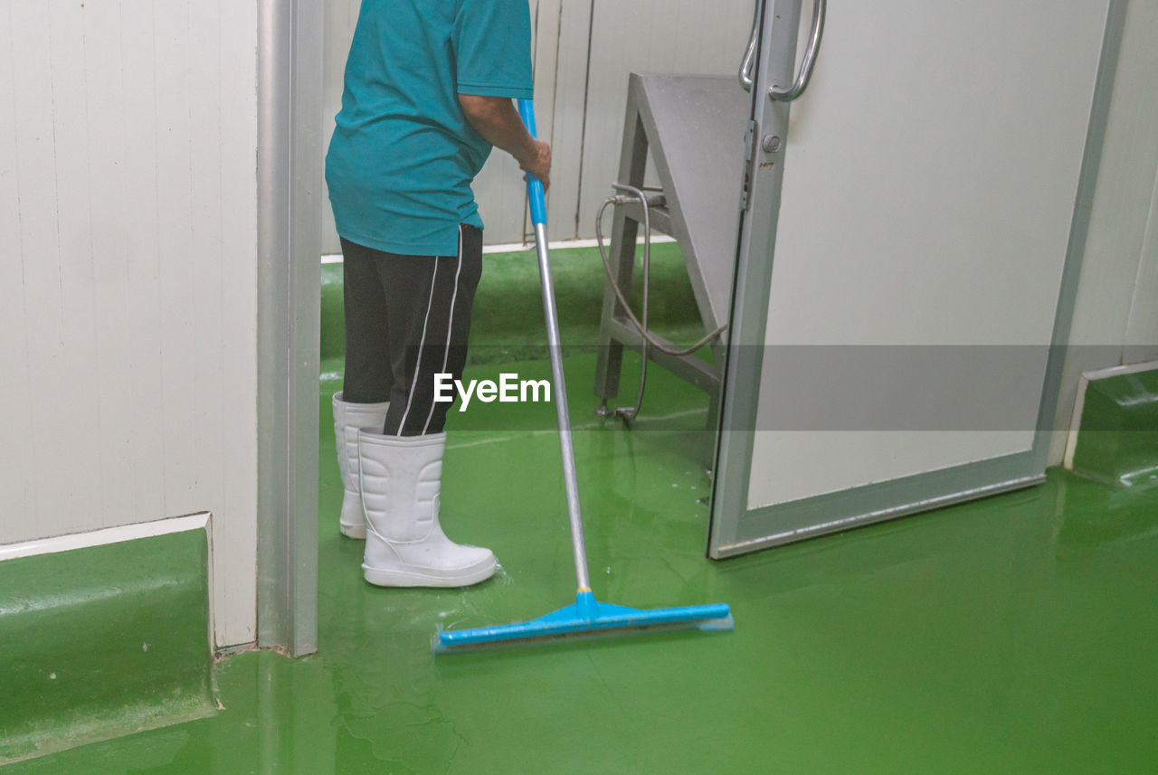 cleanliness, green, one person, adult, floor, men, indoors, room, cleaning, occupation, cleaner, working, standing, hygiene, healthcare and medicine, broom, flooring, cleaning equipment, full length, hospital, lifestyles