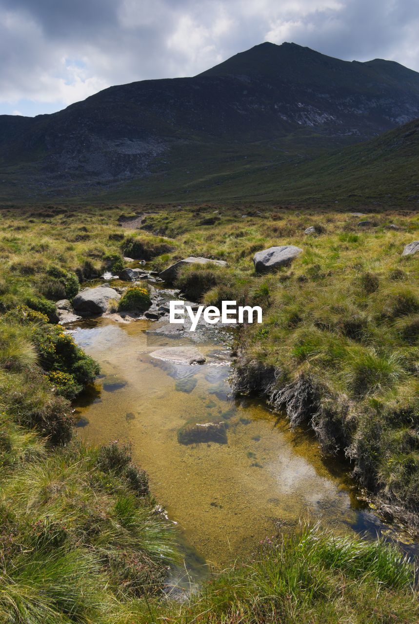 Scenic view of river and mountains against sky