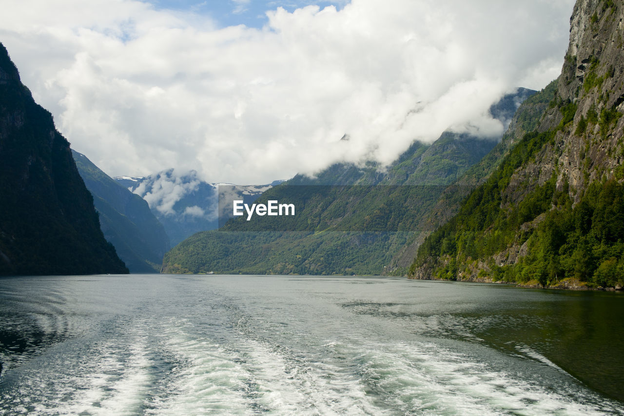 Scenic view of river and mountains against sky