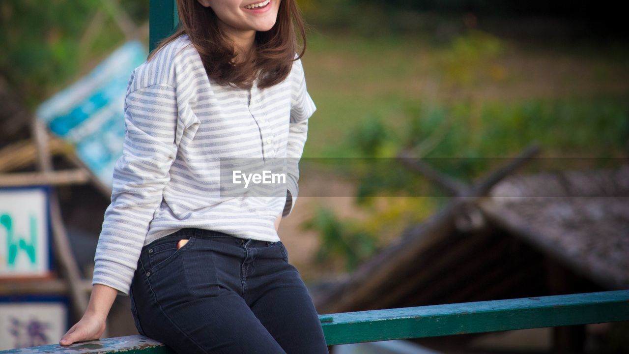 WOMAN SITTING OUTDOORS