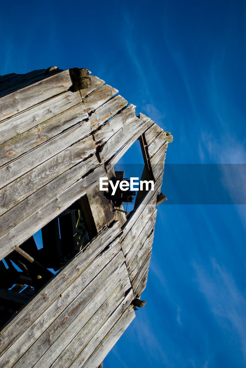 Low angle view of abandoned barn against sky