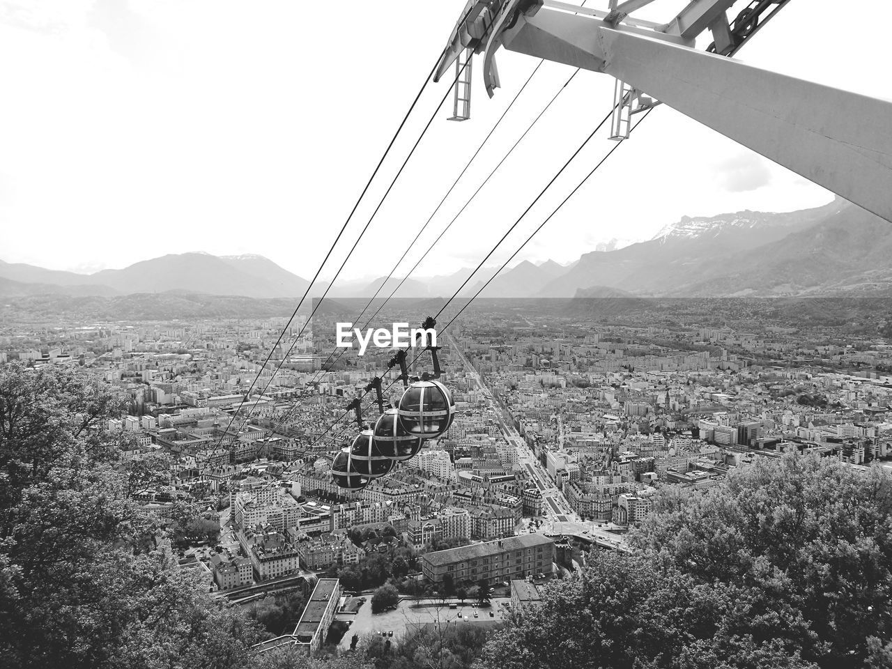 OVERHEAD CABLE CAR OVER MOUNTAINS AGAINST SKY