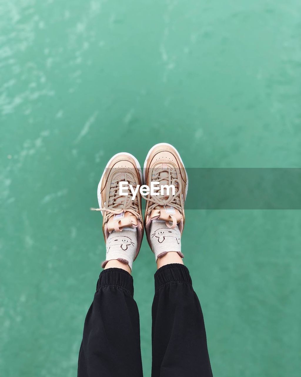 LOW SECTION VIEW OF PERSON STANDING ON GREEN LEAF