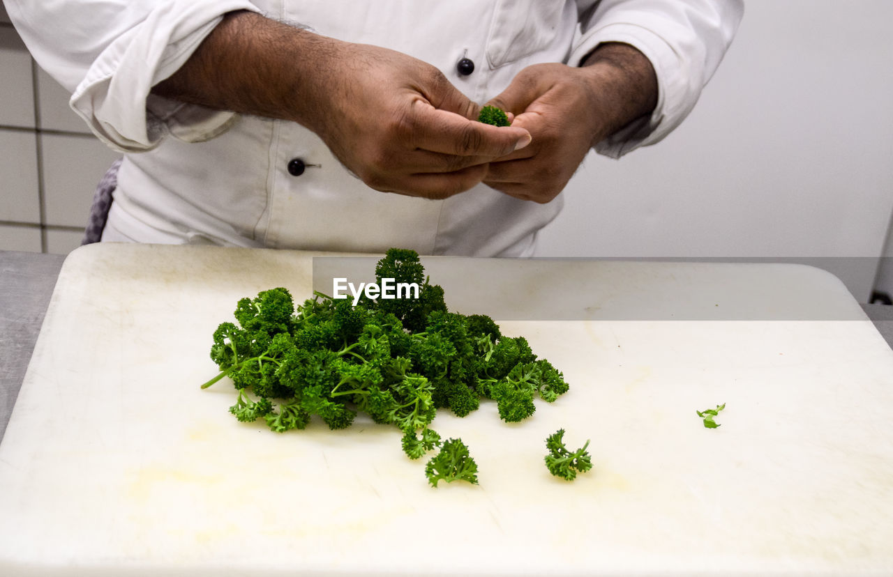 Close-up of man preparing parsley