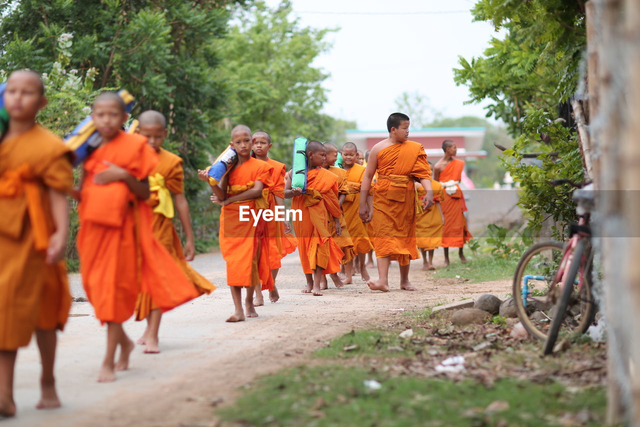 REAR VIEW OF PEOPLE WALKING IN ROW