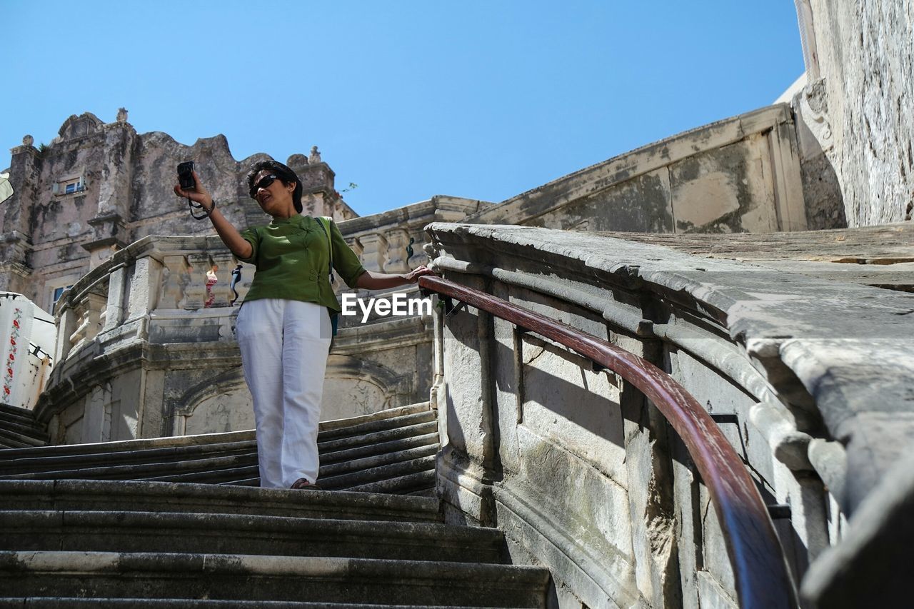 WOMAN STANDING ON STEPS