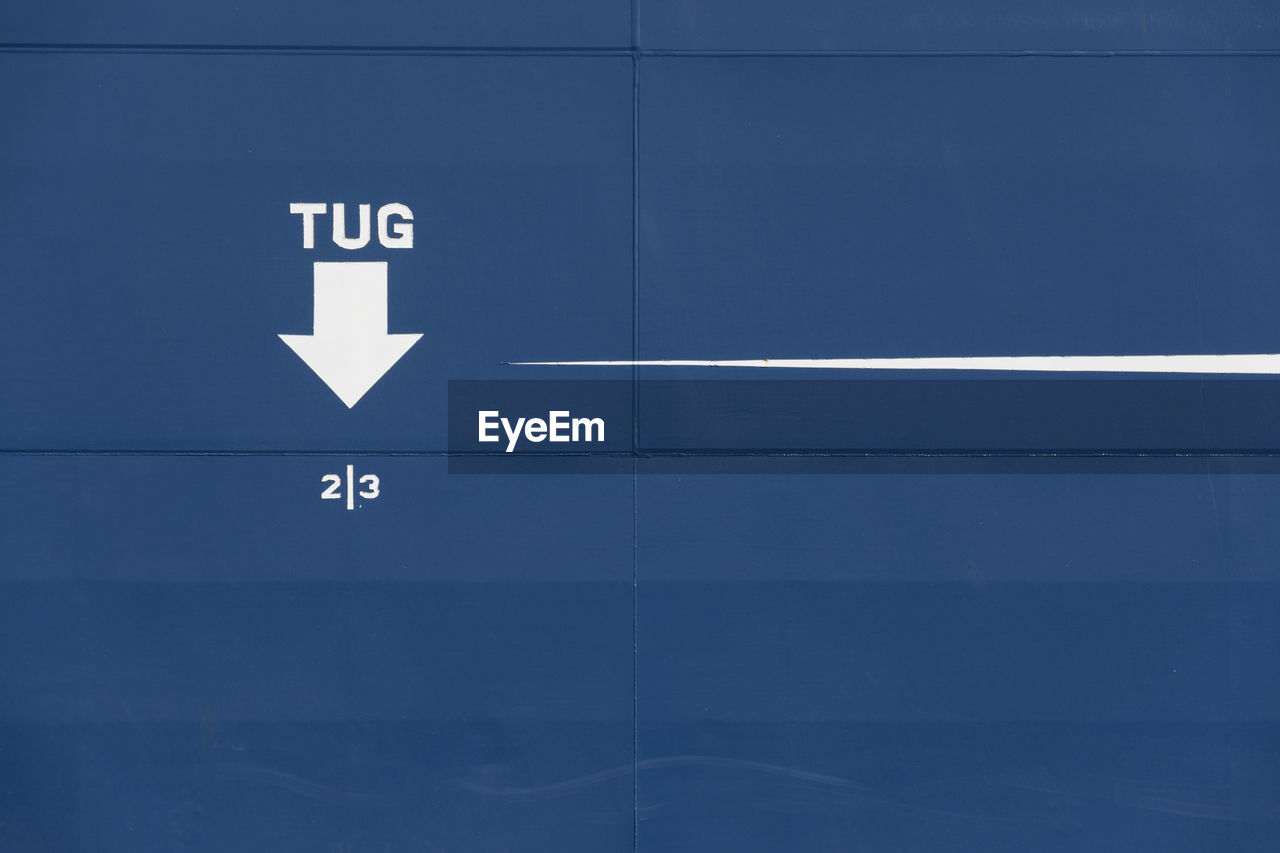 Text and arrow symbol on blue ship