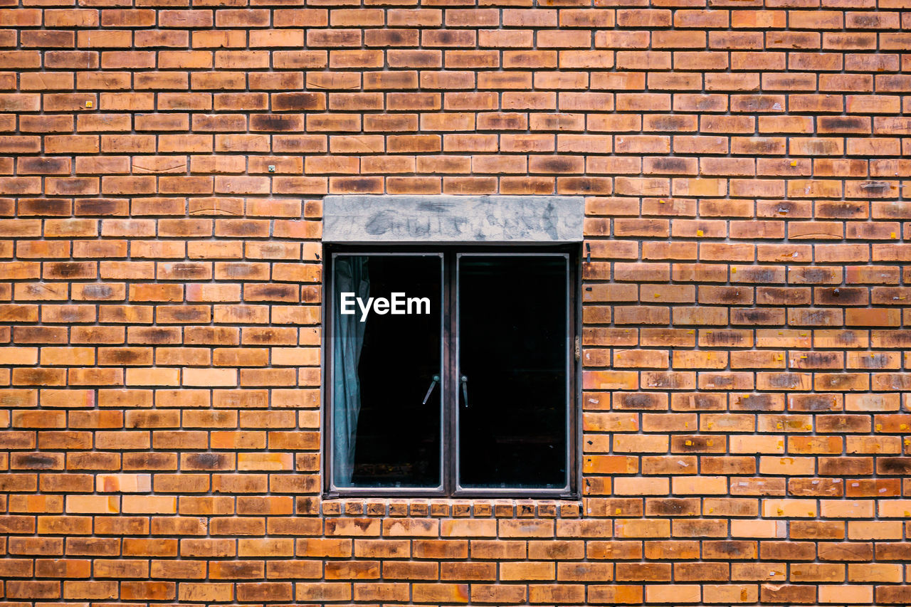 WINDOW ON BRICK WALL OF HOUSE