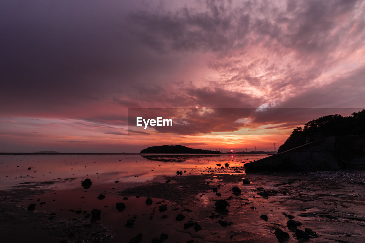 Scenic view of beach against sky during sunset