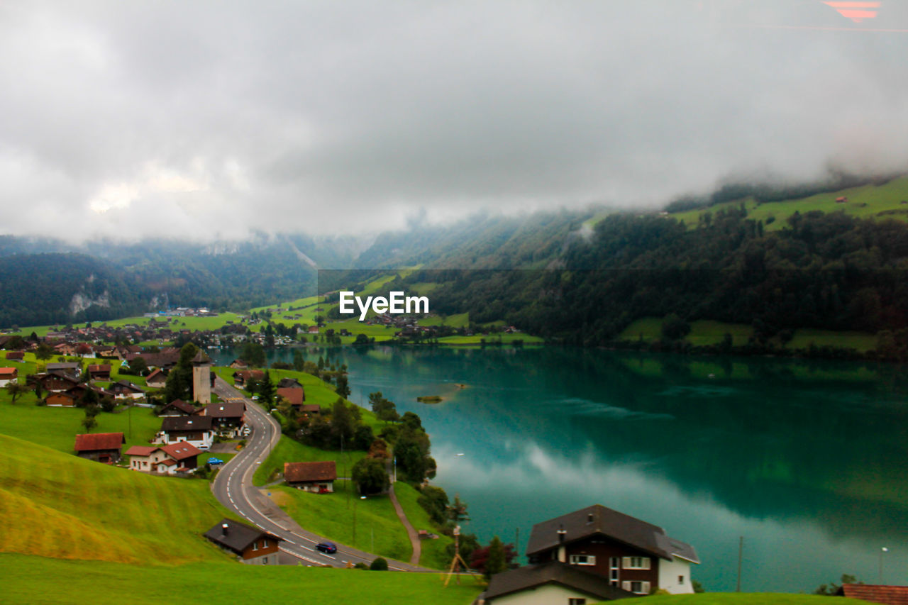 HIGH ANGLE VIEW OF LAKE AMIDST TREES AGAINST SKY