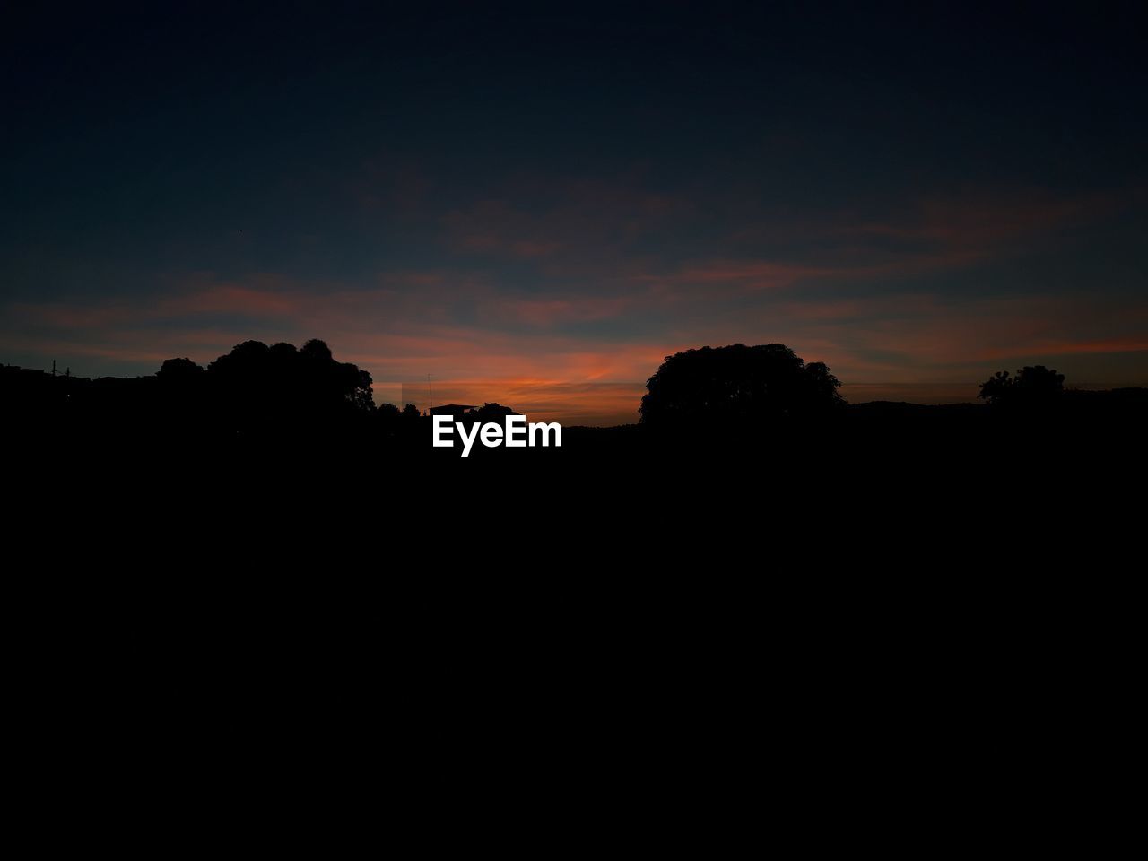 SILHOUETTE LANDSCAPE AGAINST SUNSET SKY